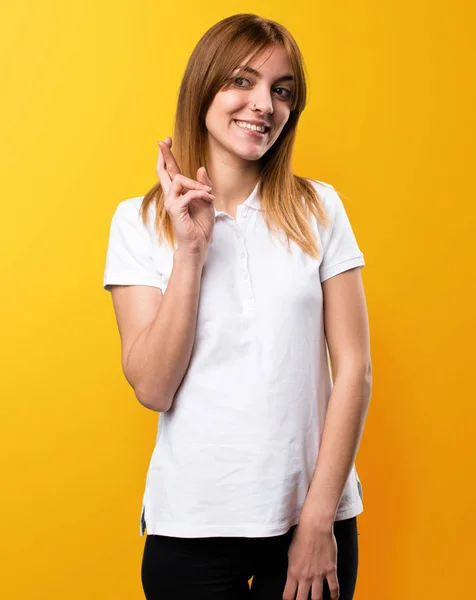 Όμορφη νεαρή κοπέλα με τα δάχτυλά της, διασχίζοντας την κίτρινο backgro — Φωτογραφία Αρχείου