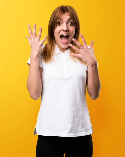 Όμορφη νεαρή κοπέλα κάνει έκπληξη χειρονομία σε κίτρινο backgroun — Φωτογραφία Αρχείου