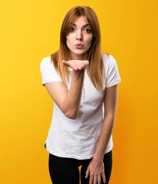 Menina bonita enviando um beijo no fundo amarelo — Fotografia de Stock