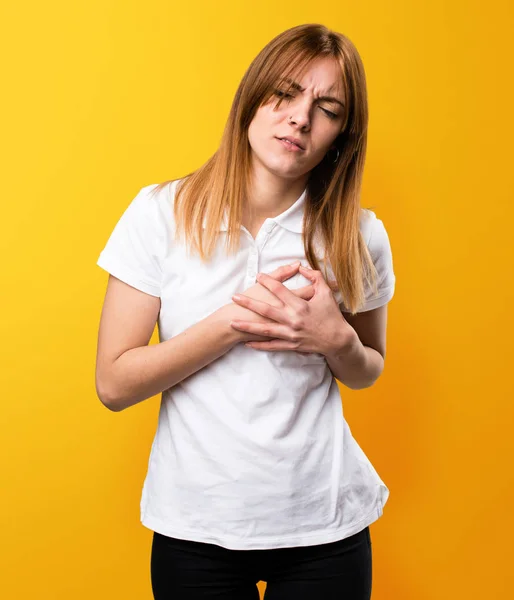 Bella ragazza con dolore al cuore su sfondo giallo — Foto Stock