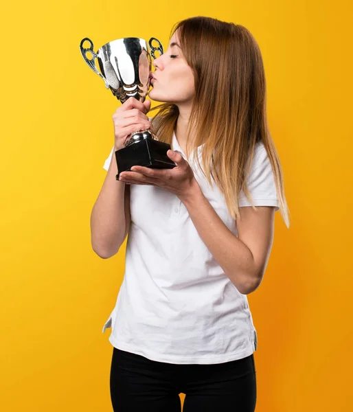 Felice Bella giovane ragazza in possesso di un trofeo su sfondo giallo — Foto Stock