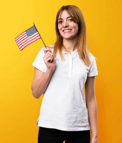 Feliz hermosa joven sosteniendo una bandera americana en amarillo ba —  Fotos de Stock