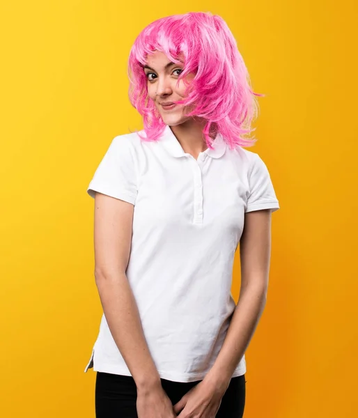 Menina bonita feliz com cabelo rosa no fundo amarelo — Fotografia de Stock