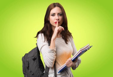 Öğrenci kadın yapma sessizlik jest renkli arka plan üzerinde