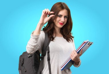 Renkli arka plan üzerinde küçük işareti yaparak öğrenci kadın