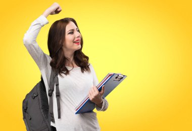 Şanslı öğrenci kadın renkli arka plan üzerinde