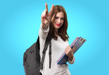 Öğrenci kadın yapma zafer jest renkli arka plan üzerinde