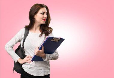 Öğrenci kadın renkli arka plan üzerinde yanal arıyor