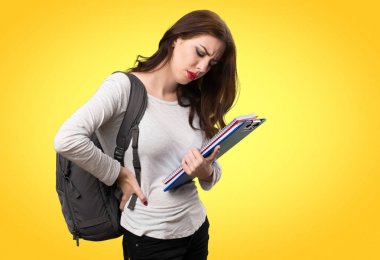 Renkli arka plan üzerinde sırt ağrısı olan öğrenci kadın