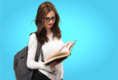 Öğrenci kadın renkli arka plan ile ilgili bir kitap okuma