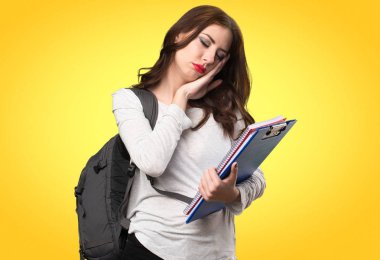 Öğrenci kadın yapma uyku jest renkli arka plan üzerinde