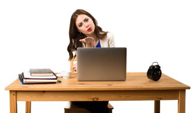 Onu laptop ile çalışan ve bir öpücük gönderme iş kadını