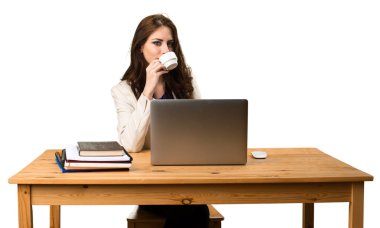 Onu laptop ile çalışan ve bir fincan kahve holding iş kadını