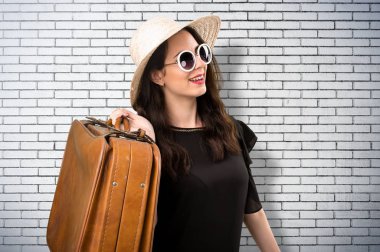 Bir tuğla duvar bavulla güzel genç kız