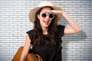 Bir şey üzerinde bir BRI gösterilen bavulla güzel genç kız