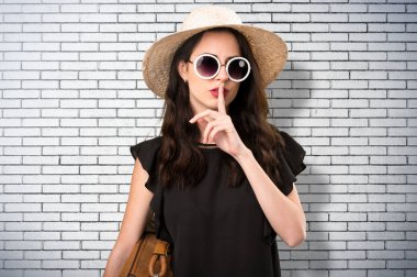 Sessizlik jest yapma bavulla güzel genç kız 