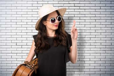 Parmaklarını çapraz bir bavulla güzel genç kızla 