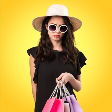 Hüzünlü güzel genç kız alışveriş çantası üzerinde renkli backgrou ile