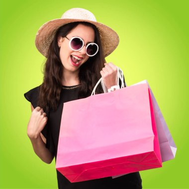 Renkli backgr üzerinde alışveriş çantası ile şanslı güzel genç kız