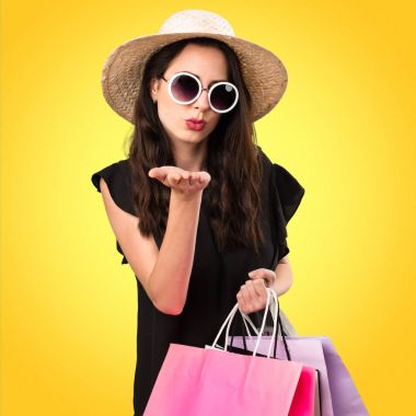 Güzel genç kız ile alışveriş çantası colorf üzerinde bir öpücük gönderme