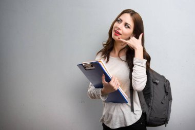 Öğrenci kadın yapım telefon jest dokulu arka plan üzerinde