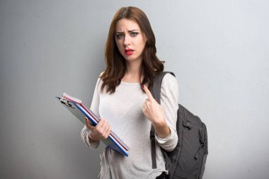 Sürpriz bir jest yapma öğrenci kadın dokulu arka plan