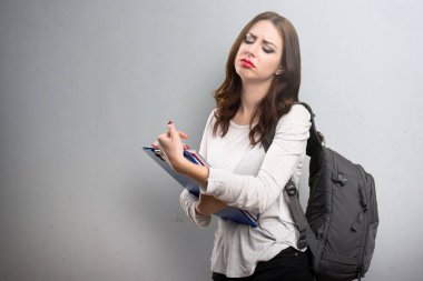 Yorgun öğrenci kadın dokulu arka plan üzerinde