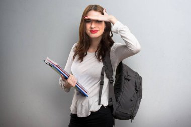 Bir şey dokulu arka plan üzerinde gösterilen öğrenci kadın