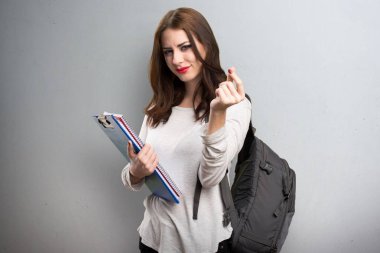 Öğrenci kadın yapım para jest dokulu arka plan üzerinde