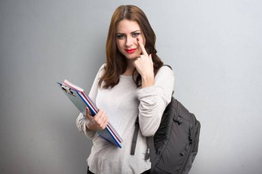 Bir şey dokulu arka plan üzerinde gösterilen öğrenci kadın