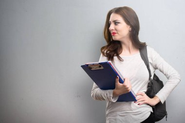 Öğrenci kadın dokulu arka plan üzerinde yanal arıyor