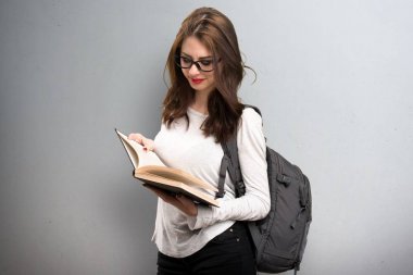 Öğrenci kadın dokulu arka plan üzerine bir kitap okuma