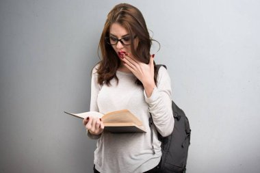 Öğrenci kadın dokulu arka plan üzerine bir kitap okuma