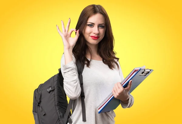 Estudante mulher fazendo OK sinal no fundo colorido — Fotografia de Stock