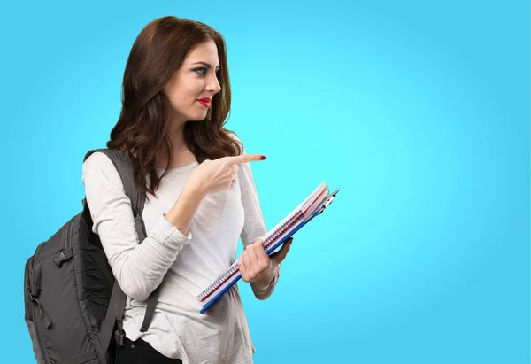 Student woman wijzend naar de laterale op kleurrijke achtergrond — Stockfoto