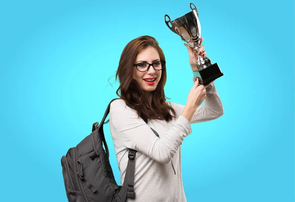 Estudante mulher segurando um troféu no fundo colorido — Fotografia de Stock