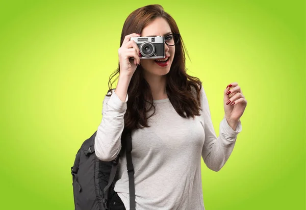 Studentka žena držící fotoaparát na barevné pozadí — Stock fotografie