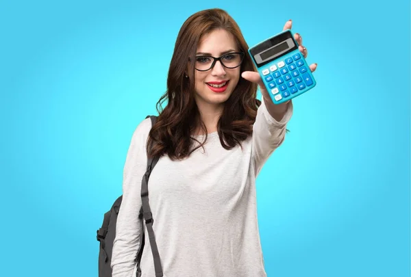 Bir hesap makinesi renkli arka plan üzerinde tutan öğrenci kadın — Stok fotoğraf