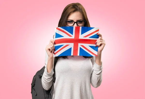 Student woman holding an United Kingdom flag on colorful backgro — Stock Photo, Image