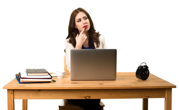 Zakenvrouw met haar laptop werken en denken — Stockfoto