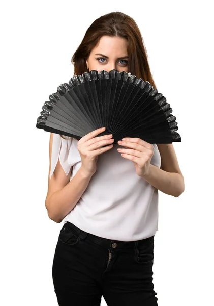 Menina bonita com um ventilador e cobrindo seu rosto — Fotografia de Stock