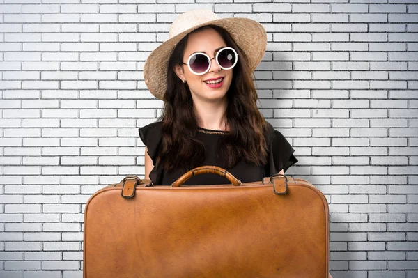 Bir tuğla duvar bavulla güzel genç kız — Stok fotoğraf