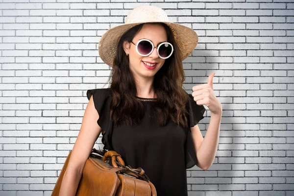 Güzel genç kız bir bavul ve bir BRI üzerinde başparmak ile