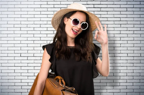 Bir tuğla üzerinde oturum Tamam yapma bavulla güzel genç kız 