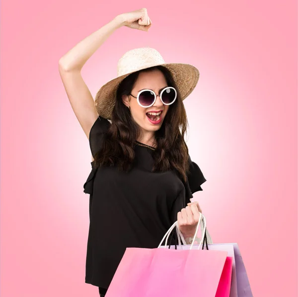 Szerencsés gyönyörű fiatal lány, a színes háttérben bevásárlószatyor — Stock Fotó
