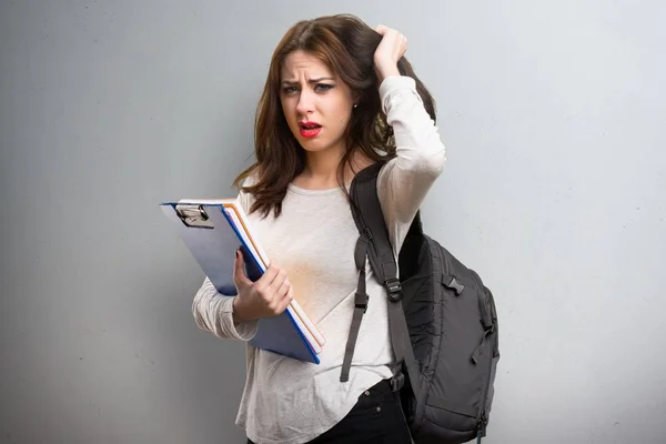 Frustrierte Studentin auf strukturiertem Hintergrund — Stockfoto
