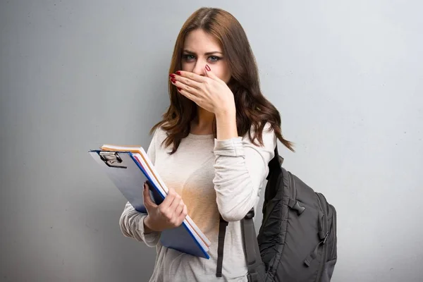 Estudante mulher cobrindo sua boca em fundo texturizado — Fotografia de Stock