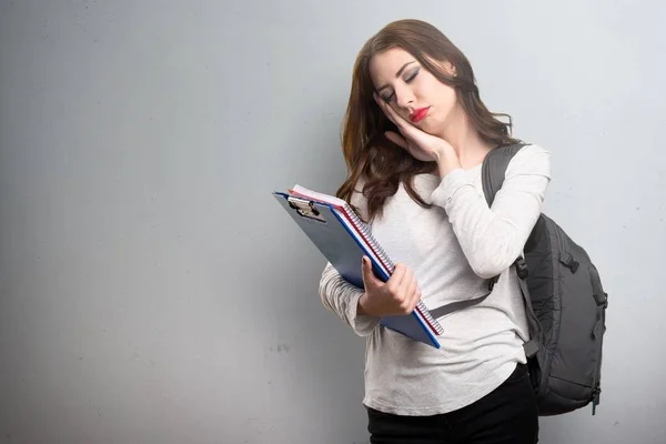 Student vrouw maken slaap gebaar op gestructureerde achtergrond — Stockfoto