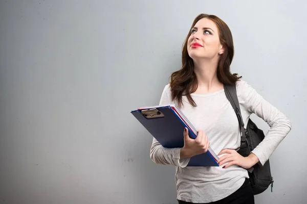 Studente donna guardando su su sfondo strutturato — Foto Stock