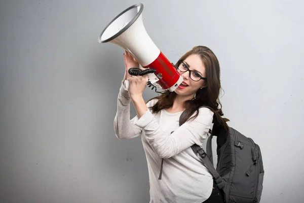 Student vrouw schreeuwen door megafoon op gestructureerde achtergrond — Stockfoto